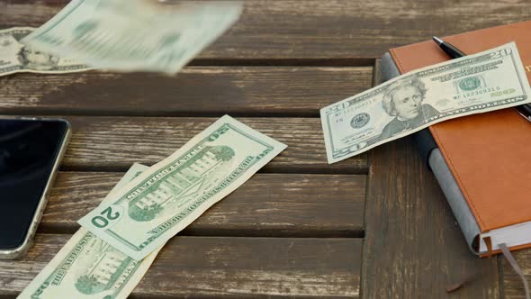 Slow Motion Hundred and Twenty US Dollar Banknotes Falling Down on Wooden Desk