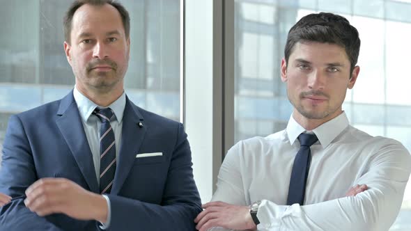 Middle Aged Businessman Standing with Assistant in Office