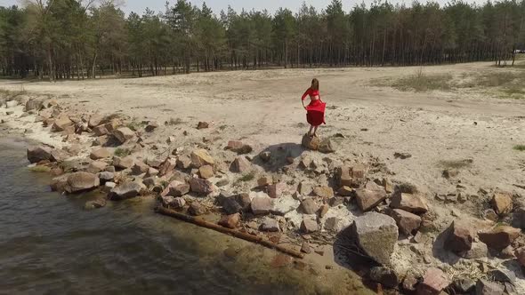 Delicate Graseful Woman in Red Long Dress Dancing Raises Hands on the Big Stone Near Spectacular