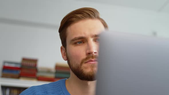 Young man checking documents using laptop