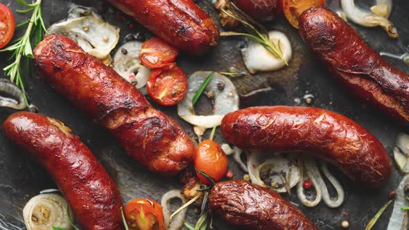 Top View on Delicious Grilled Sausages Served with Onion Tomatoes Garlic Bread and Herbs