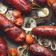 Top View on Delicious Grilled Sausages Served with Onion Tomatoes Garlic Bread and Herbs - VideoHive Item for Sale