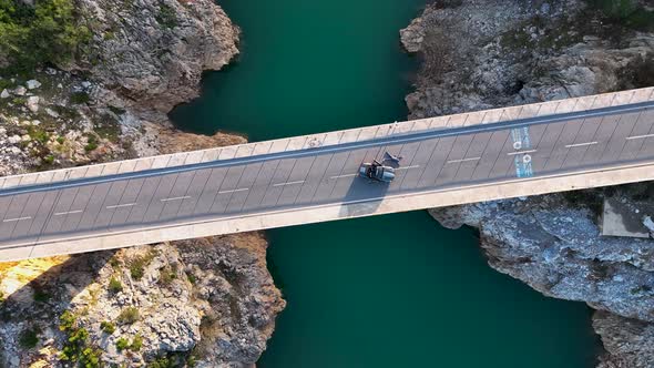 A car passes through a bridge over a river aerial view 4 K