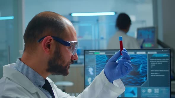 Viorolog Researcher Examining Blood Sample From Test Tube