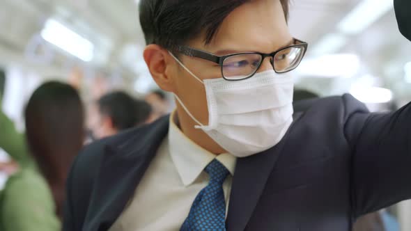 Young Man Wearing Face Mask Travels on Crowded Subway Train