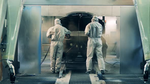 Plant Workers Are Covering an Automobile Carcass with Zinc