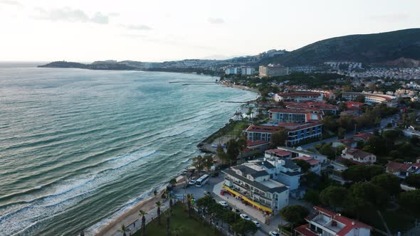 Aerial flyover beautiful Turkish coastal, holiday resort town with hotels and restaurants.