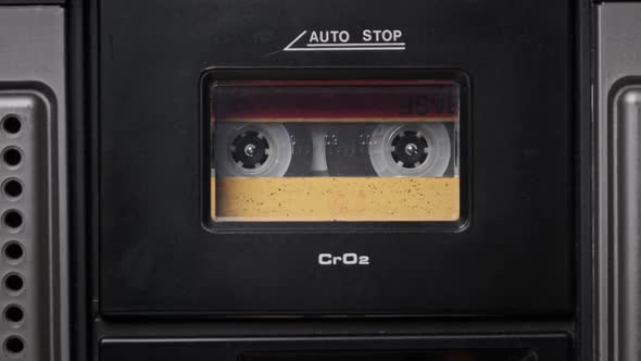 Vintage Yellow Audio Cassette Tape Rotates in Deck of an Old Tape Recorder