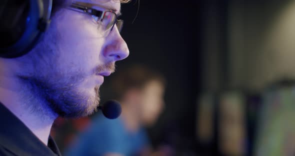 Close Up Portrait of a Gamer Playing an Online Video Game and Commenting Into a Microphone, V2
