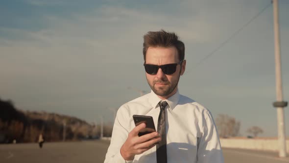 Using Mobile Phone On Nature. Holding Using Smartphone Outdoors.Businessman Chatting On Mobile Phone