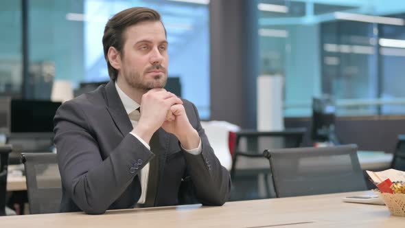 Pensive Businessman Sitting at Work Brainstorming