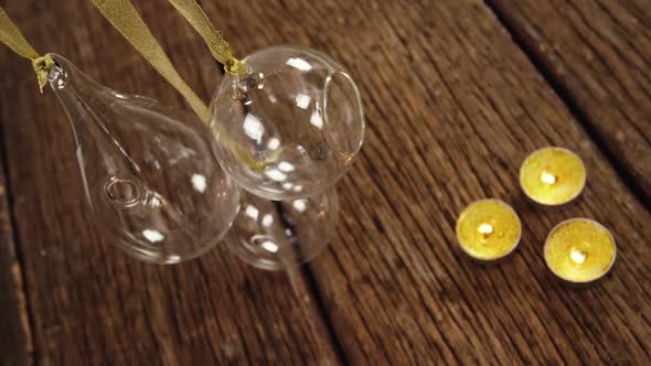 Tealight candles with hanging glass lamps on a plank