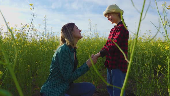 Mom and Daughter on Yellow Bloomed Rapeseed Field