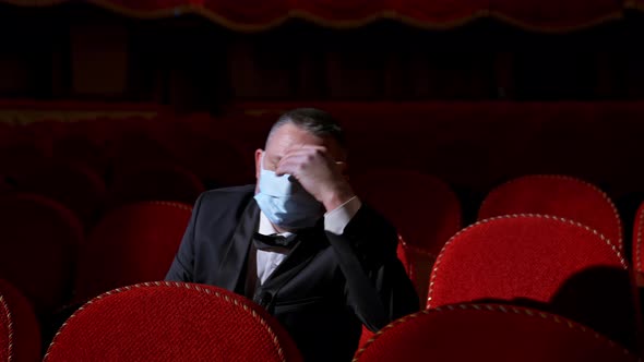 Actor in medical mask on theatre. Empty classic theater.