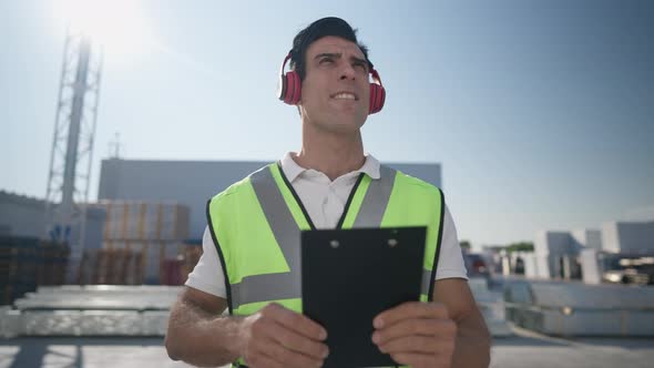 Front View of Positive Handsome Middle Eastern Warehouse Manager Checking Cargo Filling in Bill of