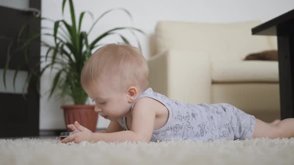 Little Boy Is Watching Cartoons on Smartphone on the Floor at Home, Lifestyle