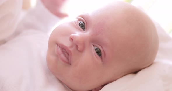 Newborn baby yawns and slightly smiles