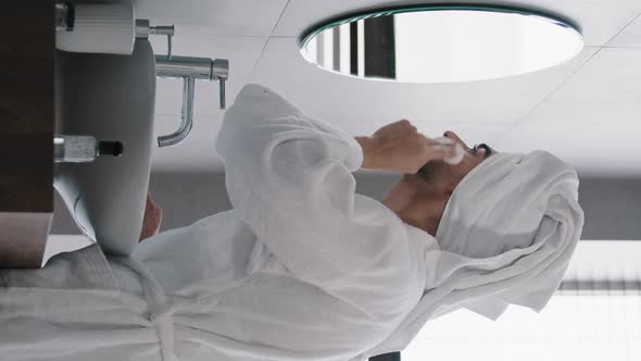 Vertical View Millennial Man Skin Care at Home at Morning Bearded Indian Guy with White Bath Towel