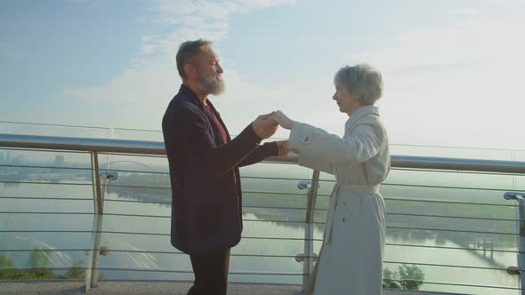 Old Aged Couple Dancing on Observation Deck in Beaming of the Sun