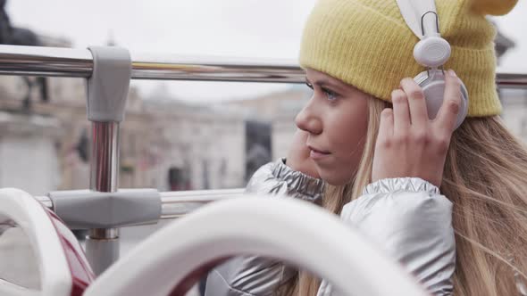 Teenage Girl Putting On Headphones On Bus