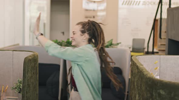 Happy Woman with Dreadlocks High-Fiving Colleagues