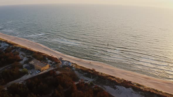 Bird'seye View a Group of People Stand on a Sandy Beach Washed By Foamy Waves