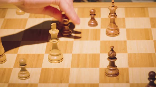 The hands of two chess players move the pieces alternately, taking some chess pieces off the chess b