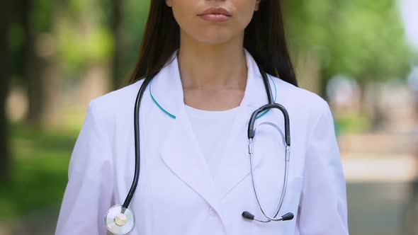 Female Doctor in White Uniform Seriously Looking at Camera, Healthcare, Closeup