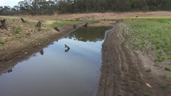 Aerial footage of a creek feeding a drought affected water reservoir in regional Australia