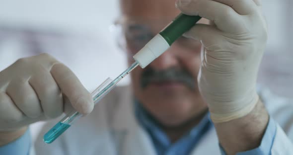 Technician Carefully Drips the Solution From the Pipette Into Glass Tubes for DNA Analysis. Doctor