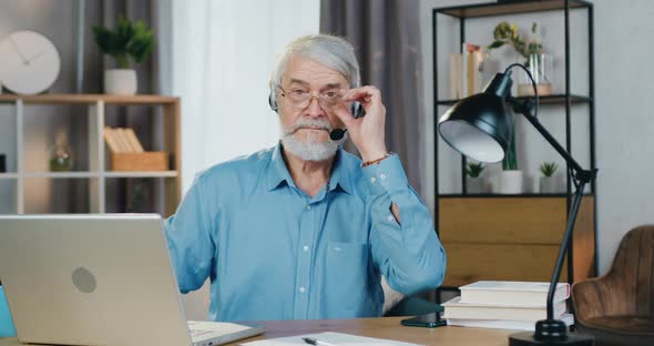 Focused Aged Entrepreneur Working on Laptop from Home