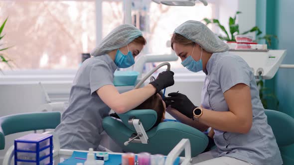 Two Woman Doctors in Medical Mask in Dental Clinic Serve the Patient Little Boy