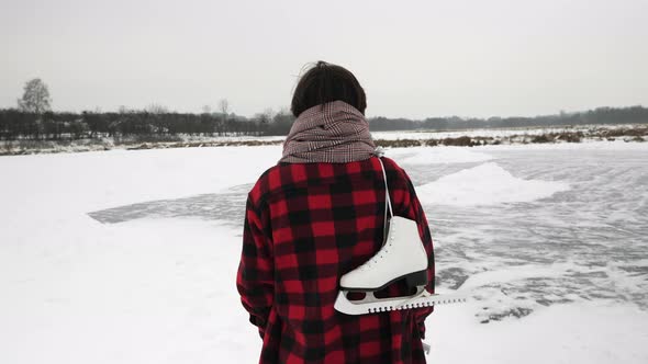 Woman with skates is on frozen ice lake