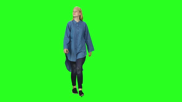 Blonde Teenager Girl Calmly Walking on Green Screen Background. Chroma Key,  Shot. Front View.