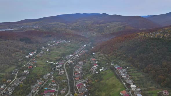 Aerial view autumn landscape with small village in a mountain valley