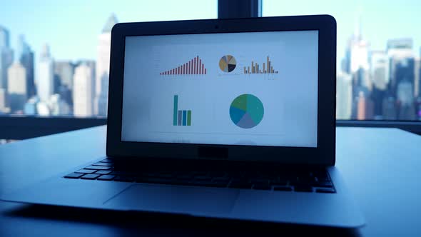 Laptop Computer Screen Desk Showing Financial Growth Charts Graphics