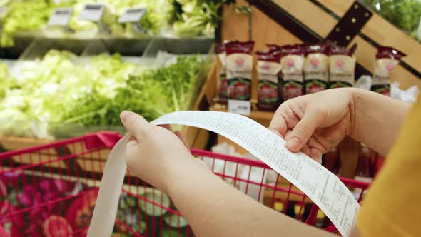 Woman Checks Paper Check After Shopping for Groceries at Mall By Checking Dear Amount Bill in a