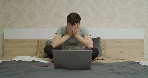 Stressed Young Man Looks at the Computer and is Very Stressed