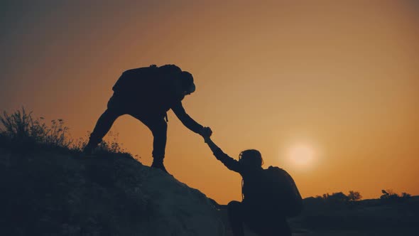 Couple Hiking Help Each Other Silhouette in Mountains. Teamwork Couple Hiking, Help Each Other