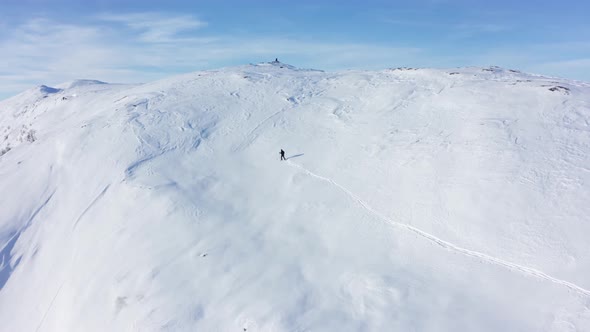 Skier surviving the cold of Hamlagro Bergsdalen Norway - Climbing up snowy hill to reach mountain to