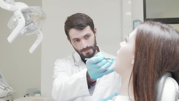 Professional Dentist Examining Teeth of a Female Patient