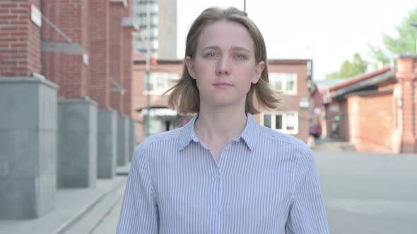 Serious Woman Walking on the Street