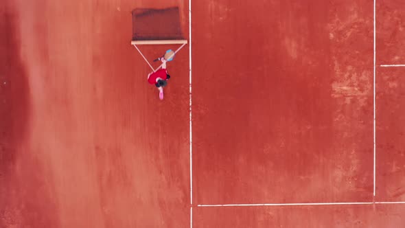 Top View of a Tennis Court with a Man Carrying a Net