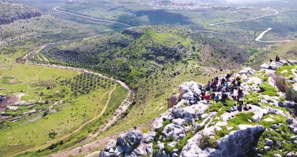 Aerial View of people admiring the landscape of the wooded hills and the paths.