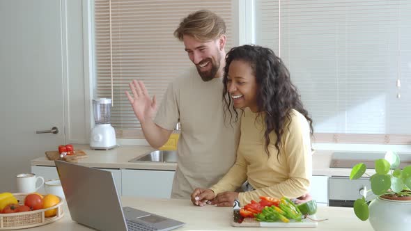 Young Heterosexual Multiethnic Couple Making a Video Call in the Kitchen