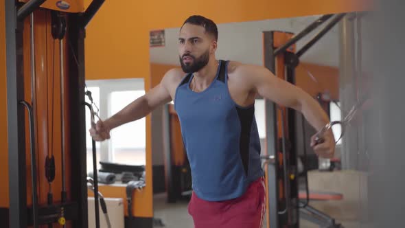 Portrait of Tense Middle Eastern Sportsman Working Out in Gym. Athletic Handsome Man Training Hand