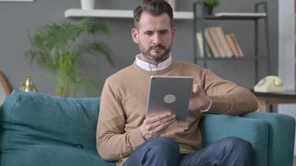 Man Using Tablet on Sofa