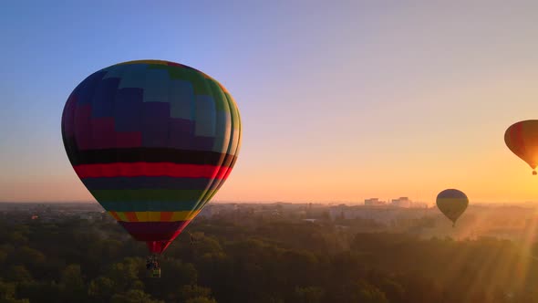 Aerial Drone View of Colorful Hot Air Balloon Flying Over Green Park and River in Small European