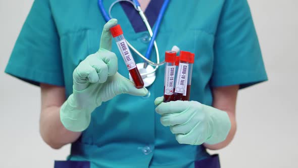 Medical Doctor Nurse Woman Wearing Protective Mask and Latex Gloves - Holding Blood Test Tube