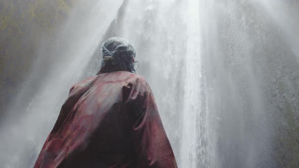 Blue Haired Woman In Awe Under Waterfall